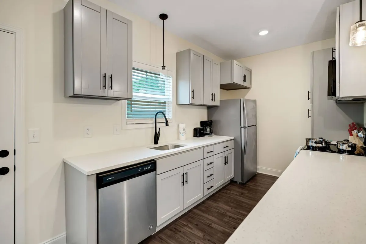 A close-up view of a contemporary kitchen featuring a polished countertop, stainless steel appliances, and beautifully coordinated cabinetry. The layout is functional yet stylish, showing a space ready for both quick meals and special recipes.